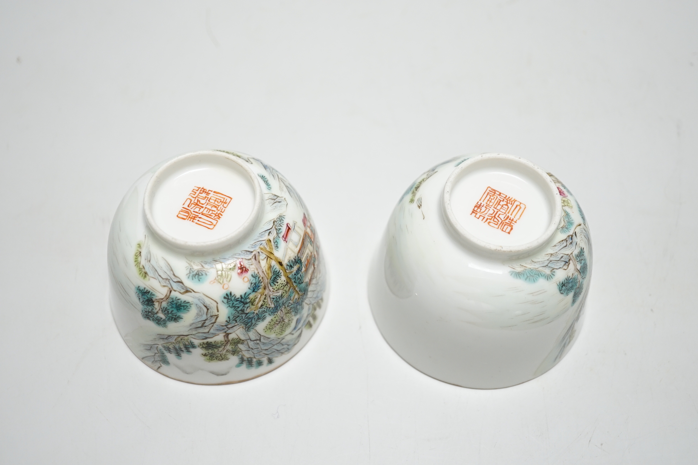 A pair of Chinese enamelled porcelain cups, landscapes and pagodas, 6cm tall